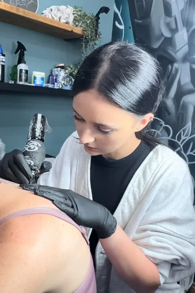 Female tattoo artist Ava working on a client in her Liverpool studio