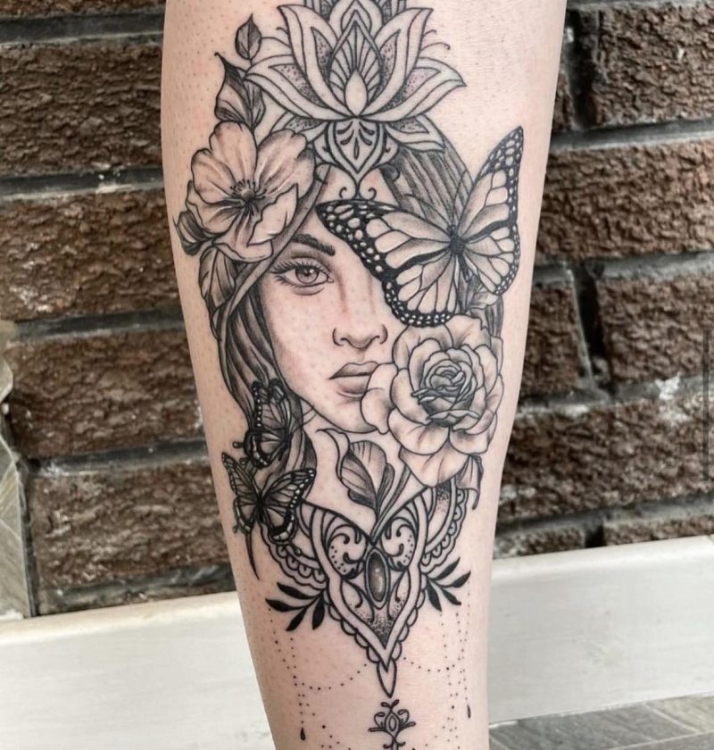 Ornate portrait tattoo of woman with butterfly mask and flowers on forearm